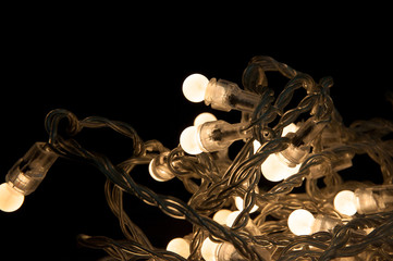 Closeup_chain of white lights_knotted_black background_by jziprian