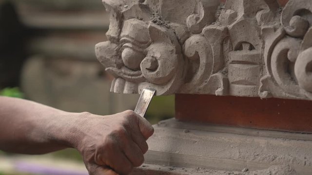 Stone carving master is making statue of a Balinese deity. 