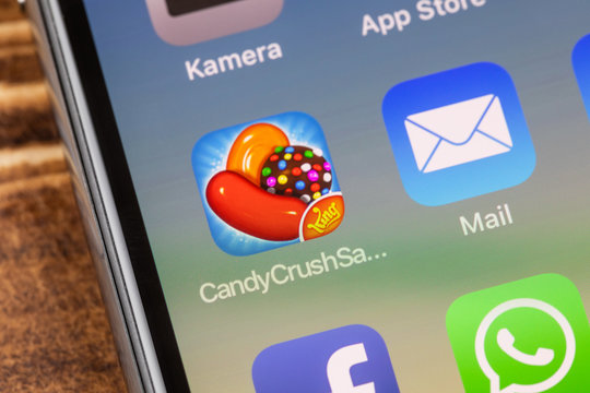 METTINGEN, GERMANY - NOVEMBER 9, 2018: Close up to candycrushsaga app on the screen of an iPhone X with personalized background