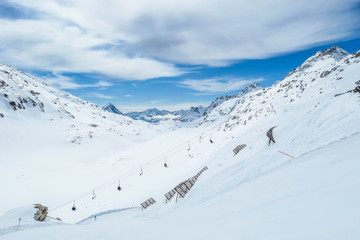 Fototapeta na wymiar Beautiful and serene landscape of mountains covered with snow in Mölltaler Gletscher, Austria. Thick snow covers the slopes. Clear weather. Perfectly groomed slopes. Massive ski resort. Glacier skiing