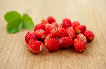 Ripe berries of a wild strawberry on a wooden surface