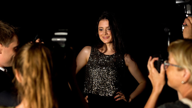 Popular glamorous female singer posing for paparazzi cameras on luxury event