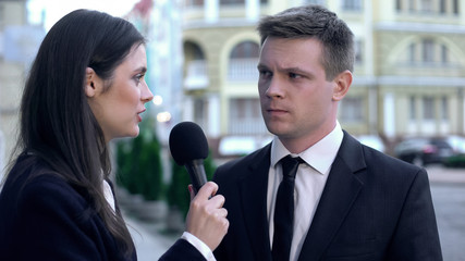 Journalist asking businessman provocative questions, recording reportage