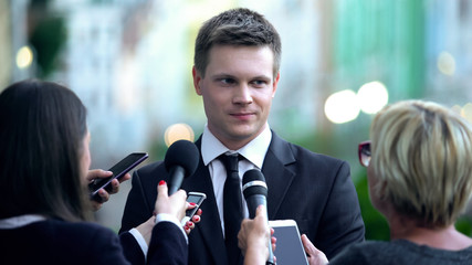 Smiling male millionaire giving interview on press conference, public relations