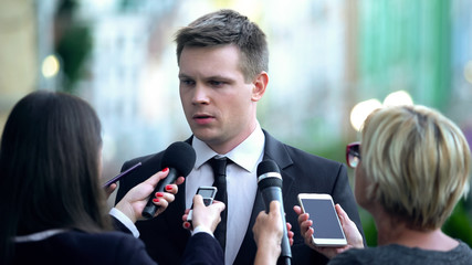Unsatisfied politician giving interview to newspaper journalists, problem