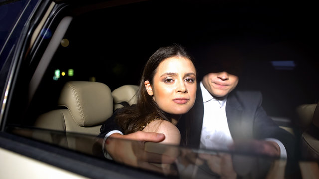 Dissatisfied couple sitting in car, paparazzi photographing, revealing secret