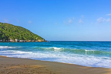 Caribbean beach with tropical forest in Tayrona National Park, Colombia. Tayrona National Park is located in the Caribbean Region in Colombia.