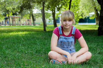 Girl sitting on green grass