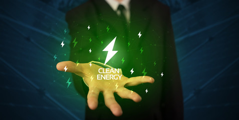 Hand in suit holding lightning bolt on his hand, green environment concept