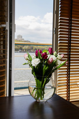 Bouquet of flowers in a vase on a coffee table in the interior of the room