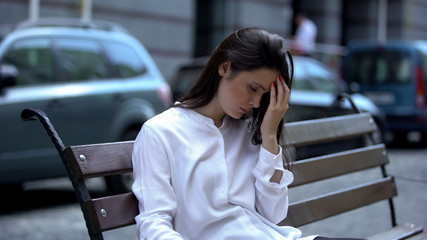 Obraz premium Tired lady sitting on bench, fighting with sleeping desire, overworking problem