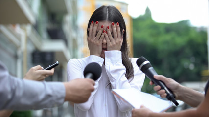 Ashamed businesswoman closing face with hands on press conference, scandal - obrazy, fototapety, plakaty