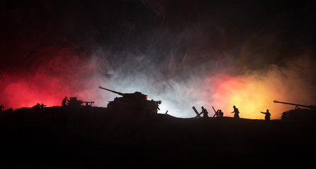 Naklejka na ściany i meble War Concept. Military silhouettes fighting scene on war fog sky background, World War German Tanks Silhouettes Below Cloudy Skyline At night. Attack scene. Armored vehicles and infantry.