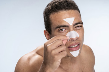 Young man finishing his morning skin cleansing