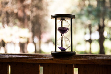 Sand running through the bulbs of an hourglass measuring the passing time in a countdown to a...