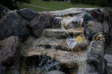 Glass of martini cocktail at swimming pool with ocean and palm tree background. A glass of blue martini cocktail welcome drink bar.Selective focus. season and holidays concept.