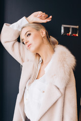 Fashionable beautiful young blondie woman posing in trendy fashionable coat outdoors. Beauty,...