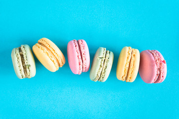 Rank of multicolored french macaroons on the blue background