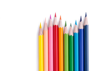 Fototapeta premium Set of bright multicolored wooden pencils lying in the form of a wave with copy space for text isolated on white background