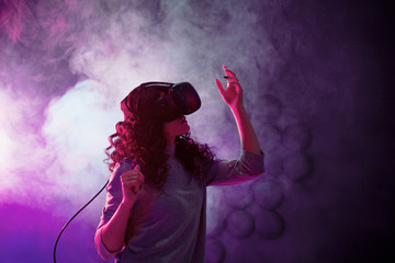 Virtual reality game. A girl in a VR helmet plays a game or explores the environment.