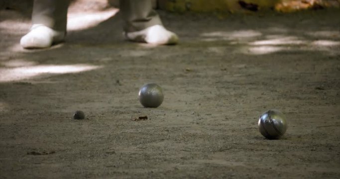 Carreau ball shot (one ball knocking another one). Close up shot with a guy with white shoes in the background. 