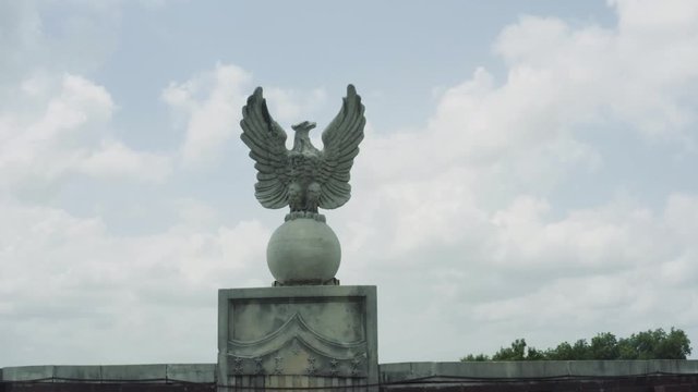 An American bald eagle stone statue resting on the Great Seal of the United States of America on top on a Texan government building. 