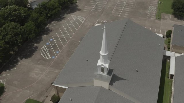 Top Of A Church With A White Steeple, Surround By An Empty Parking Lot.