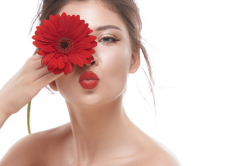 Naklejka na ściany i meble beauty woman face with red lipstick sending kisses and holding flower near her eye