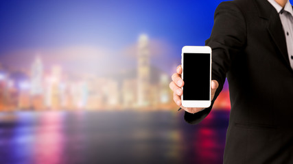 Business man hold smartphone on blur capital city background