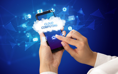 Female hand holding smartphone with CLOUD COMPUTING inscription, cloud technology concept