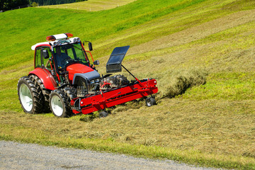 Fototapeta premium Tractor in the field , Hohe Salve mountain, Soll, Austrian Alps