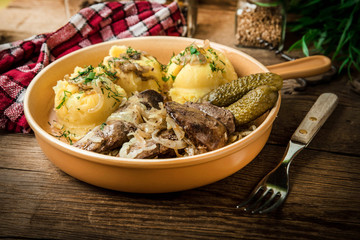 Fried chicken liver with onion served with mashed potatoes and pickled cucumber.