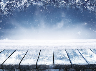 Empty blue winter christmas scenic landscape with copy space. Wooden table with snow and fir-trees covered with snow on nature.