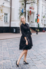Fashion photosession of professional model in the city in trendy black dress. Fashion , trendy concept