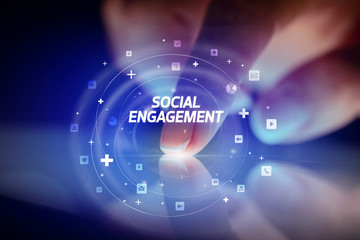 Finger touching tablet with social media icons and SOCIAL ENGAGEMENT