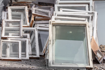 Large pile of old windows with frames is after replacing new windows in the building outside