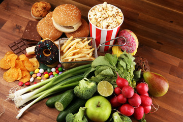 healthy or unhealthy food. Concept photo of healthy and unhealthy food. Fruits and vegetables vs donuts and fast food