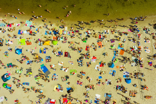 Top view of the beach in Gdansk, Poland. The beach is located on the shores of the Baltic Sea. Crowds of people swim and sunbathe on the Baltic Sea on a hot sunny day. 