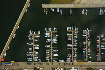 Aerial view of a white motor yacht. Yacht enters the bay in the parking lot. Gdynia, Poland. Many...