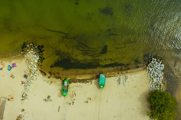 Suburb of Gdynia-Poland. Aerial view of fishing boats moored on the beach shore. Two green ships...