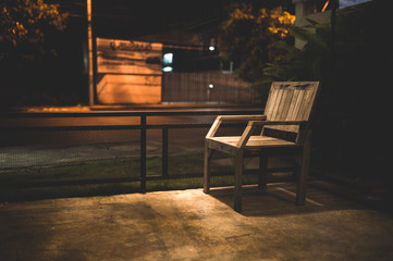 Plakat Empty wooden chair with street light at night