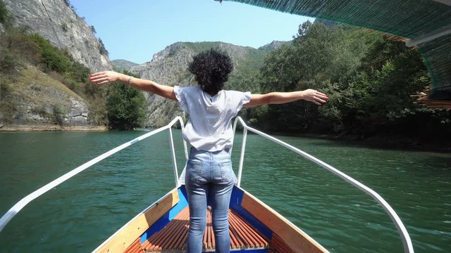 Woman with her arms open enjoying the summer breeze and bautiful Matka lake on a sunny day in Skopje, Macedonia