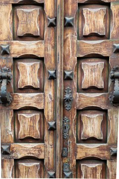 Antique wooden carved door with iron handles.