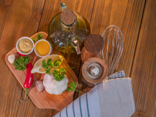 Top view of the mayonnaise ingredients on rustic wood background and olive wood cutting board.