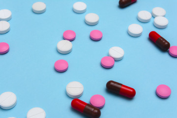 Tablets close up / Various colorful pills macro on blue background, top view.