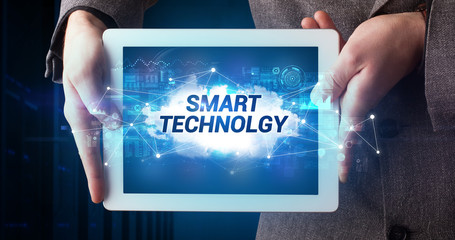 Young business person working on tablet and shows the inscription: SMART TECHNOLGY