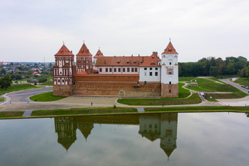 Naklejka na ściany i meble Mirsky Castle and its reflection in the lake in summer.