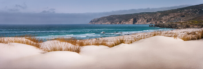Panoramic costal view of Praia do Guincho Beach with Cresmina Dunes in foreground. Cascais,...