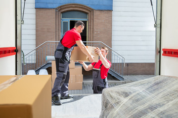 Young Movers Unloading The Boxes In The Van