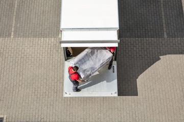 Mover Unloading The Furniture From Truck